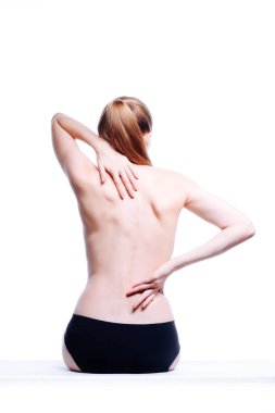 Güzel atletik kadın vücudu. Sırt ağrısı. Şortlu çıplak kadın. Beyaz arka planda izole edilmiş, arka planda stüdyo görüntüsü..