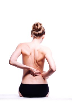 Güzel atletik kadın vücudu. Sırt ağrısı. Şortlu çıplak kadın. Beyaz arka planda izole edilmiş, arka planda stüdyo görüntüsü..