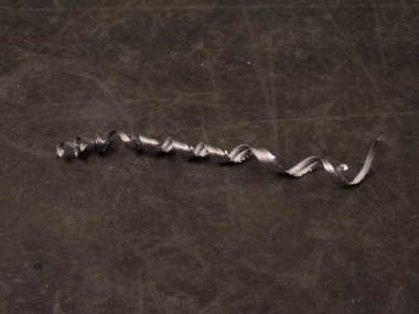 Siyah bir kauçukta bir parça alüminyum cips veya cüce.