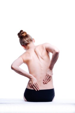Güzel atletik kadın vücudu. Sırt ağrısı. Şortlu çıplak kadın. Beyaz arka planda izole edilmiş, arka planda stüdyo görüntüsü..