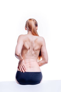 Güzel atletik kadın vücudu. Sırt ağrısı. Şortlu çıplak kadın. Beyaz arka planda izole edilmiş, arka planda stüdyo görüntüsü..