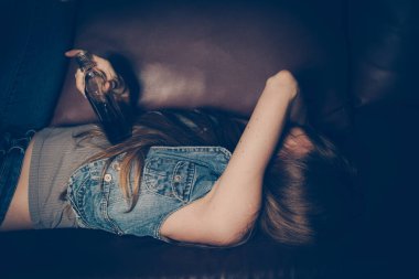 Kanepede yatan genç sarhoş kadın. Depresyon kavramı. Sağlıksız yaşam tarzı.