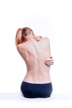 Güzel atletik kadın vücudu. Sırt ağrısı. Şortlu çıplak kadın. Beyaz arka planda izole edilmiş, arka planda stüdyo görüntüsü..