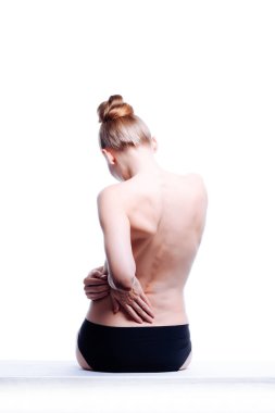 Güzel atletik kadın vücudu. Sırt ağrısı. Şortlu çıplak kadın. Beyaz arka planda izole edilmiş, arka planda stüdyo görüntüsü..