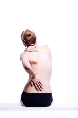 Güzel atletik kadın vücudu. Sırt ağrısı. Şortlu çıplak kadın. Beyaz arka planda izole edilmiş, arka planda stüdyo görüntüsü..
