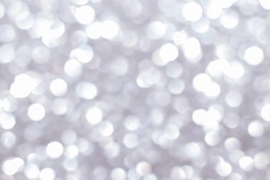 Bokeh ışıkları olan gümüşi ışıltılı bir arka plan. Yeni yıl, Noel tatilleri ve yıldönümleri için kutlama konsepti.