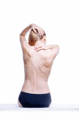 Güzel atletik kadın vücudu. Sırt ağrısı. Şortlu çıplak kadın. Beyaz arka planda izole edilmiş, arka planda stüdyo görüntüsü..