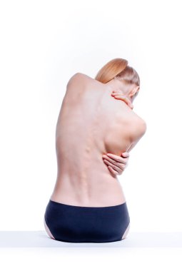 Güzel atletik kadın vücudu. Sırt ağrısı. Şortlu çıplak kadın. Beyaz arka planda izole edilmiş, arka planda stüdyo görüntüsü..