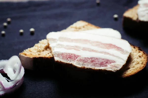 Sandwich with lard with black bread on the tablecloth on the wooden table — Stock Image Sandwich Lard Black Bread Tablecloth Wooden Table Royalty Free Stock Images