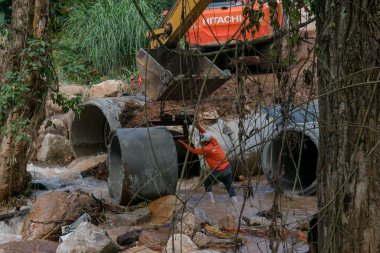 Chiangrai / Tayland - 20 Ağustos 20018, selden sonra yol rehabilitasyonu, nehirde beton halka döşeyen işçi, Chiangrai - Chiangmai yolu 118