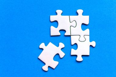 Jig saw bulmaca mavi bir arka plan üzerinde beyaz taşları