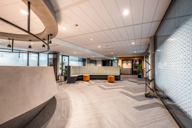 Modern bir ofis binasında resepsiyon ve bekleme alanının geniş açılı çekimi