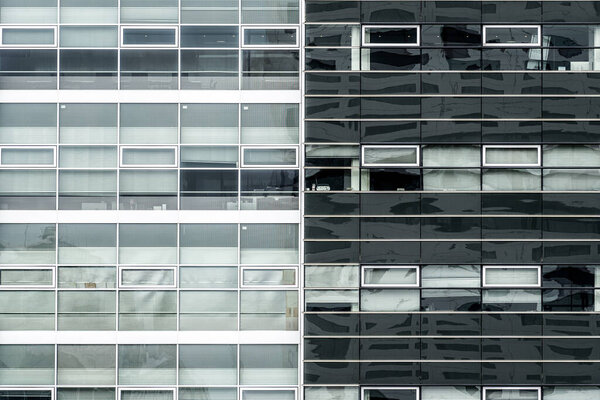 Fragment of the facade of a modern office building, the surroundings reflected in the facade