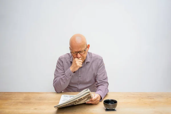 Homem Caucasiano Sentado Atrás Uma Mesa Lendo Jornal Enquanto Bebe — Fotografia de Stock