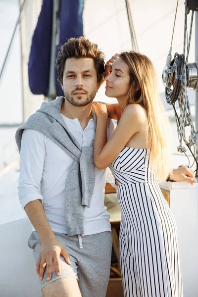 Beautiful couple on a yacht sailing on a river at sunset
