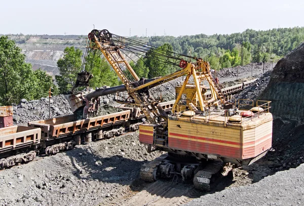 Escavatore carico di minerale di ferro nel carro merci sulla miniera di minerale di ferro a cielo aperto — Foto Stock