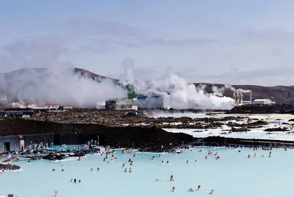 Blue Lagoon jeotermal banyo beldesinde, İzlanda banyo insanlar. Arka planda jeotermal santrali