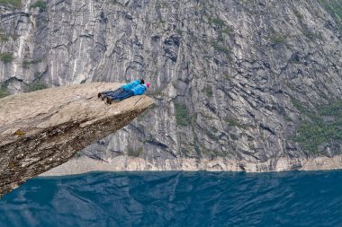 Trolltunga rock (Troll dil rock) ve Norveç dağ manzarası arayan insanlar yalan
