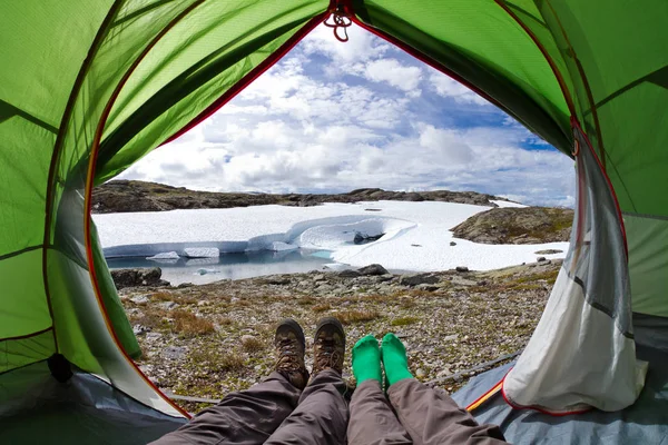 Dan güzel bir İskandinav göl kenarında bir çadır içinde görüntüleyin. Turistler manzaralı dağ manzarası Norveç'te bir çadırda yalan