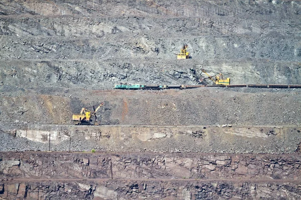 Grävmaskin laddar järnmalm i varor vagn på järnmalm dagbrott mine. Krivoy Rog, Ukraina — Stockfoto