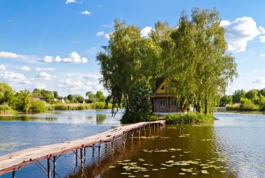 Küçük ev bir ada. Köprü'den, göl kenarında ev ile manzara. Eski Solotvyn Köyü, Ukrayna