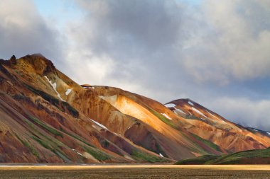 Gün batımında İzlanda dağ manzarası. Renkli volkanik dağlar Landmannalaugar geotermal. Laugavegur iz kısmı