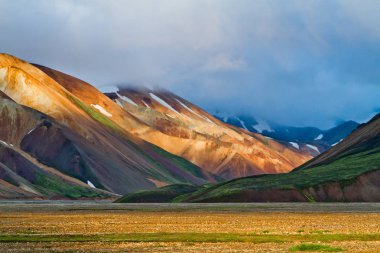 Gün batımında İzlanda dağ manzarası. Renkli volkanik dağlar Landmannalaugar geotermal. Laugavegur iz kısmı