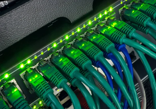 绿色网络电缆连接到交换机发光的特写 — 图库照片