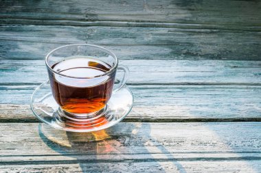 ahşap arka plan üzerinde siyah çay şeffaf bardak