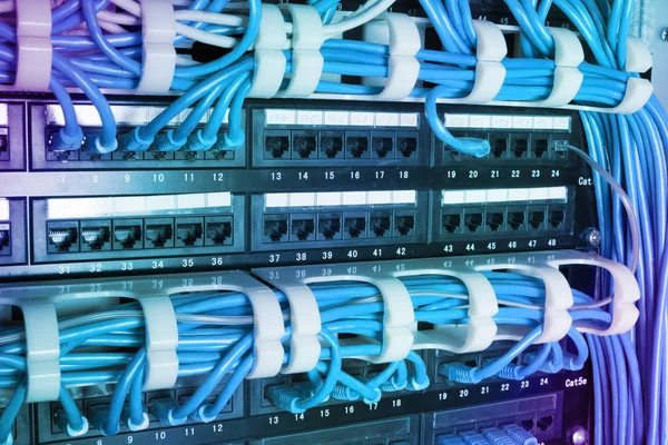 Network switch and ethernet cables glowing in server room — Stock Photo, Image