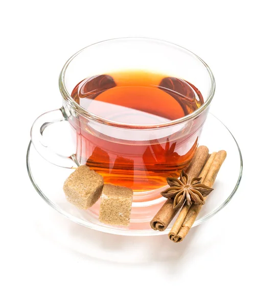 Przezroczysty kubek herbaty, cukru, anyżu i cynamon steki na białym — Zdjęcie stockowe
