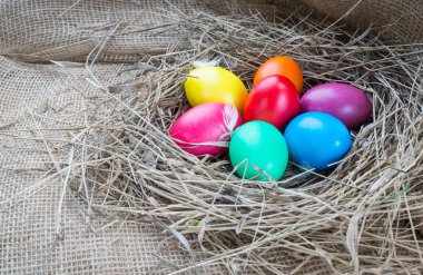 Saman çul arka plan üzerinde renkli Paskalya yumurtaları