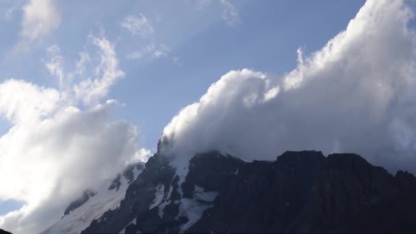 Nuages s'écrasent dans un sommet de haute montagne — Video