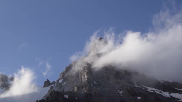 Nuages s'écrasent dans un sommet de haute montagne — Video