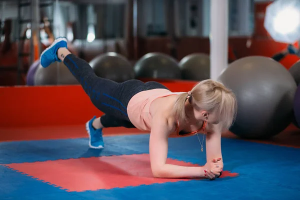 Frau in einem Fitnessstudio macht eine Reißverschlussübung — Stockfoto