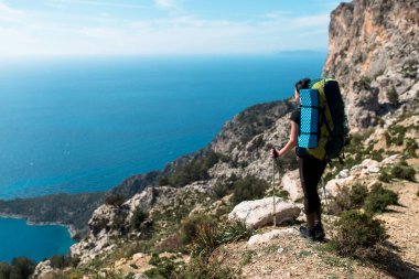 Kız denizdeki dağlara bakar.