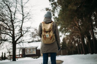 Kız, kışın ormanda sırtüstü duruyor.