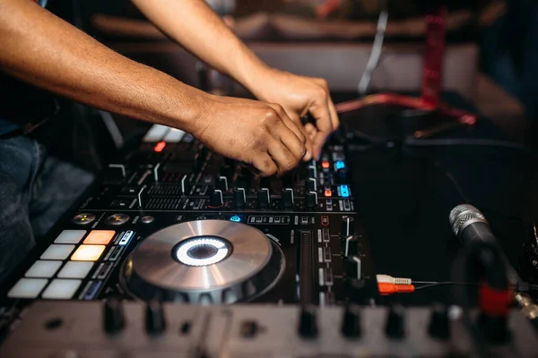 Close up of DJ\'s hand playing music at turntable on a party festival