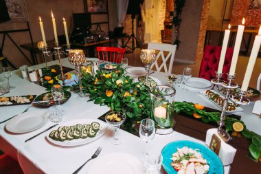 Yapraklarla süslenmiş şenlik masası kayısı greyfurt yüksek bardaklar restoran arka planında yaldızlı