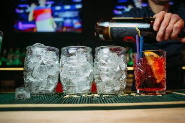 Barmen bir restoranda kokteyl yapar.