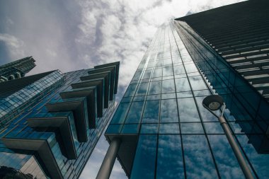 Güneşe karşı mavi gökyüzüne bakan iki gökdelen manzarası