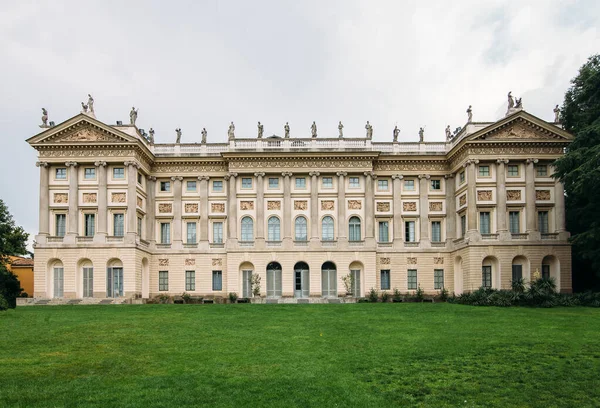 old big building on green grass and cloudy sky