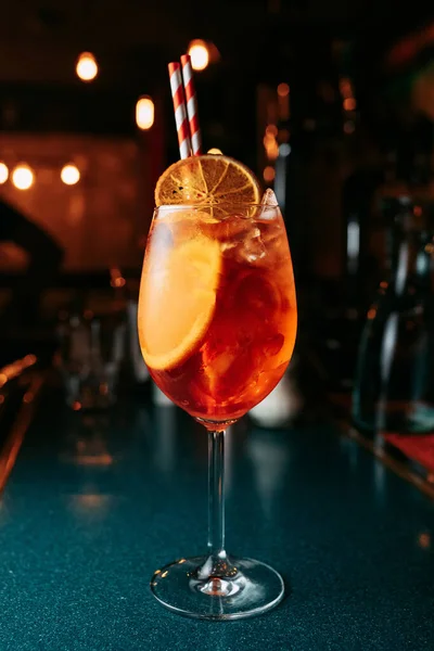 Alcoholic  summer Cocktail. Alcoholic beverage based on table with ice cubes and oranges.