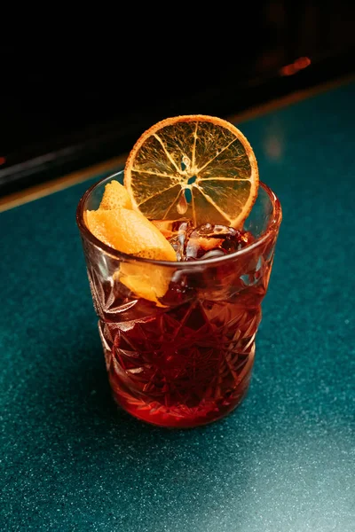 Alcoholic  summer Cocktail. Alcoholic beverage based on table with ice cubes and oranges.