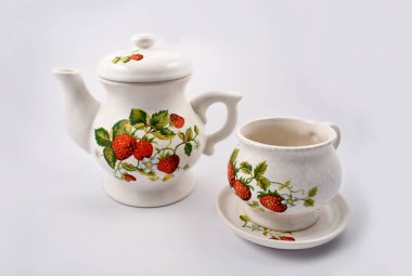 Çilek çay takımı hazır görüntüler. Çaydanlık kupa üzerinde beyaz bir arka plan ile. Seramik çilek desenli