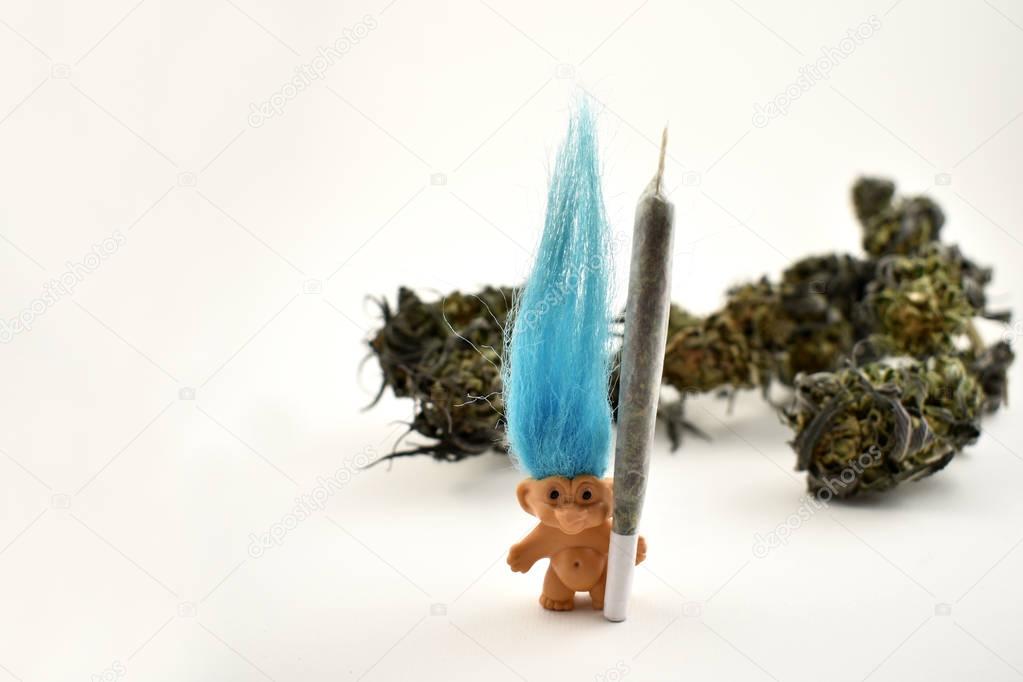 Troll with marijuana stock images. Elf on a white background. Troll with blue hair. Marijuana isolated on a white background. Funny troll with a joint