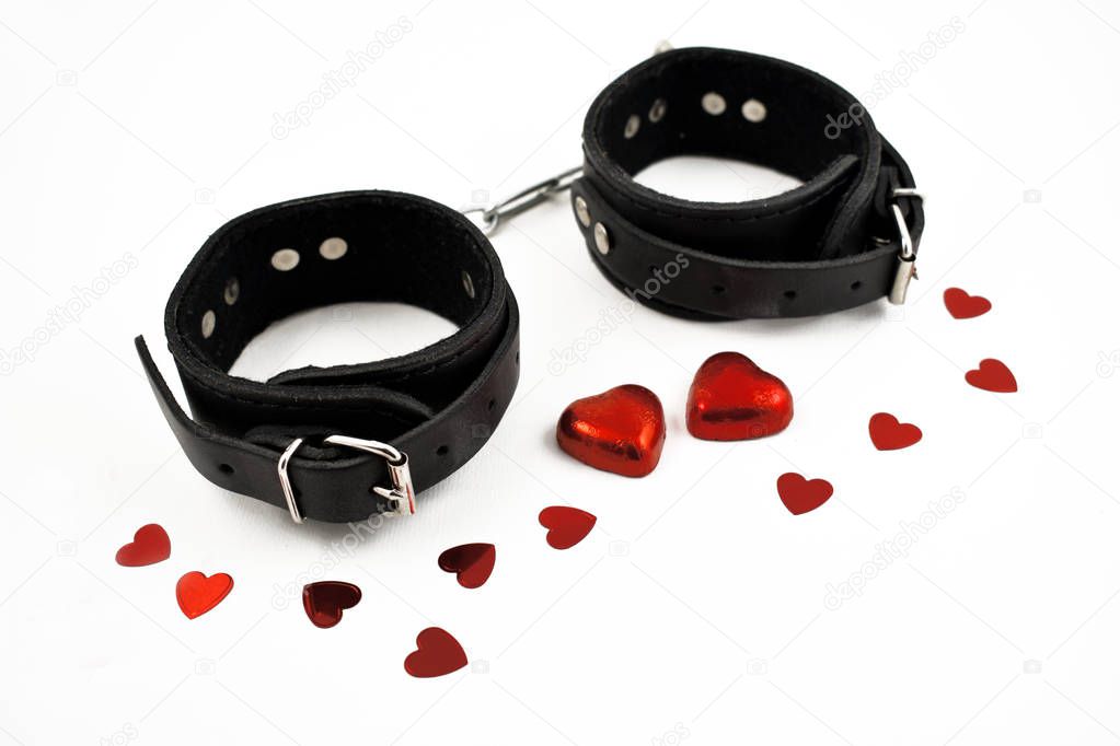 Handcuffs with hearts stock images. Leather Handcuffs on a white background. Romantic Handcuffs on a white background. Valentines Day concept. BDSM tool