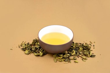 Bir fincan yeşil çay hazır görüntüler. Kahverengi zemin üzerine yeşil çay. Gevşek yeşil çay. Çin çay Kupası