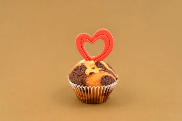 心のストック イメージのマフィン 茶色の背景にハートとチョコレートのマフィン 甘いバレンタイン菓子 バレンタインの日の概念 — ストック写真