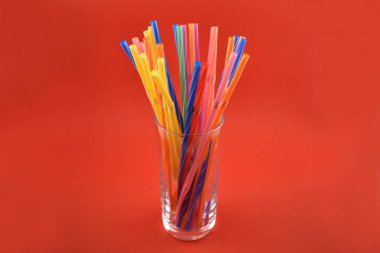 Renkli payet hazır görüntüler. Plastik çubuk kırmızı bir arka plan üzerinde renkli. Renkli içme payet